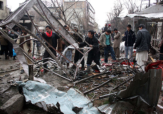 Kabul explosions: Afghan volunteers remove debris from the scene of a suicide bomb attack