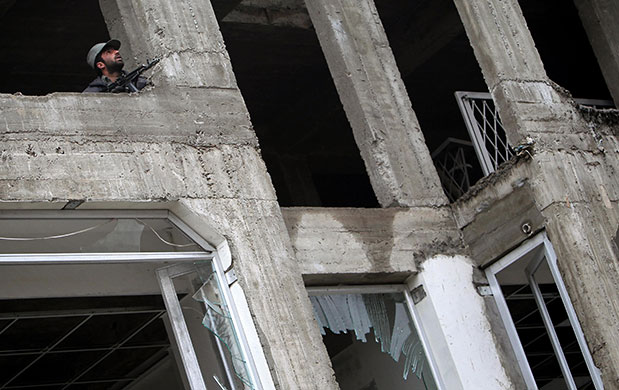 Kabul explosions: An Afghan security official looks out from the Park Residence Guesthouse