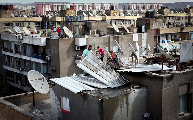 24 Hours in Pictures: Residents in Cairo repair their home after a freak lightning and hail storm