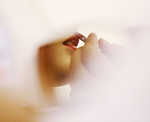 24 Hours in Pictures: A model is reflected in a small mirror as her lipstick is adjusted 