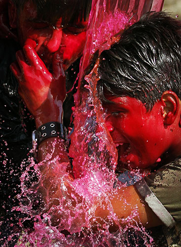 24 Hours in Pictures: Indian children pour dyed water on each other to celebrate Holi festival