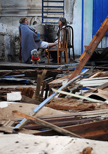 Chile Earthquake: Two women sit by a fire with their dog in Valparaiso