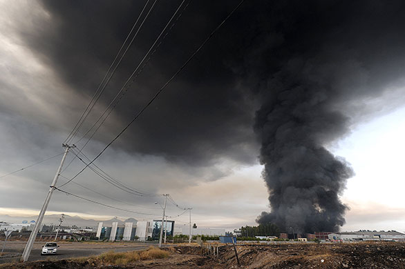 Chile Earthquake: Smoke from a burning building fills the sky in the outskirts of Santiago
