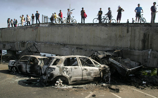 Chile Earthquake: People look at destroyed cars after Chile earthquake