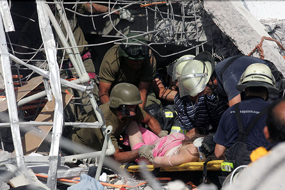 Chile Earthquake: Rescue workers help an injured woman in Concepcion, Chile