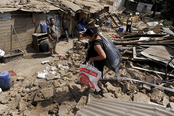 Chile Earthquake: A woman recovers belongings Santo Domingo Street in Santiago, Chile