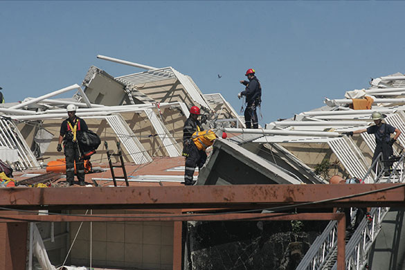 Chile Earthquake: Rescue workers inspect a damaged building in Concepcion