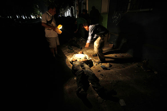 24 hours in pictures: Residents look at the body of a dead man after Chile earthquake