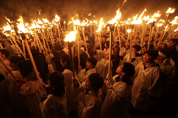 24 hours in pictures: South Koreans wearing traditional Korean costumes carry torches