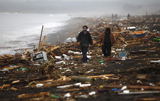 chile update: People walk along the shore after an earthquake in Pelluhue, Chile