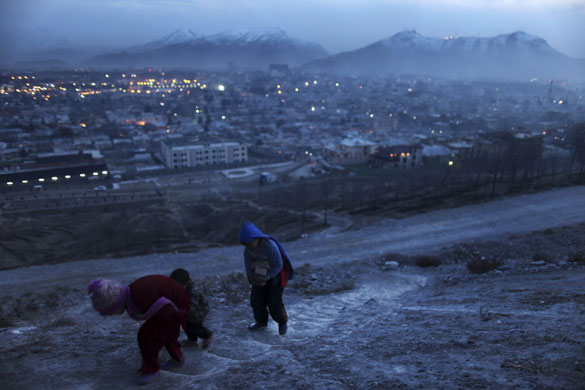 Eyewitness: Kabul, Afghanistan: Children, one carrying bricks, walk up a steep hillside