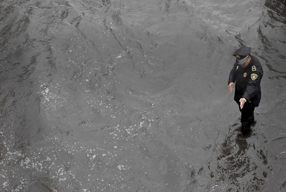 24 hours: Mexico City, Mexico: A policeman directs traffic in a flooded street  