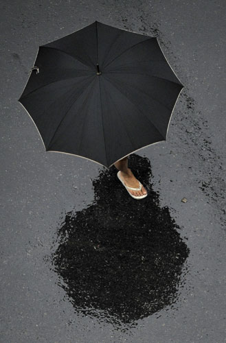 24 Hours in Pictures: A woman crosses a street under heavy rain in Buenos Aires