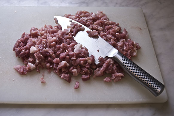 Making salami: 4. Go over the pile roughly with a big chopping knife 