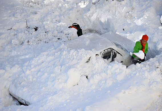 24 hours in pictures: Chevy Chase, US: A woman digs her car out of the snow