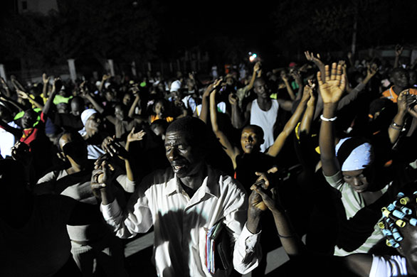 24 hours in pictures: Port-au-Prince, Haiti: People hold hands and wave their arms