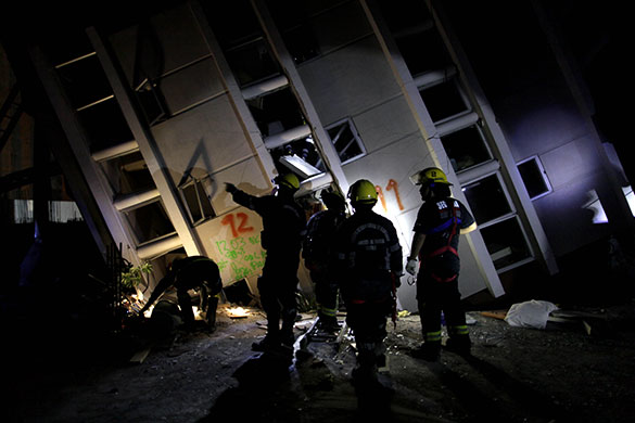 Chile earthquake: Firemen look for survivors in a building in Concepcion