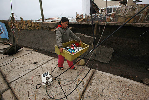 Chile earthquake: A girl recovers her belongings from her house destroyed by an earthquake