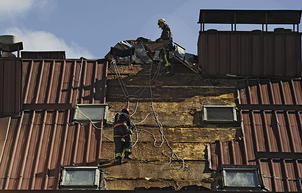 Storm damage in Europe: Fireman work on a damaged roof after a storm in the Basque city of Vitoria