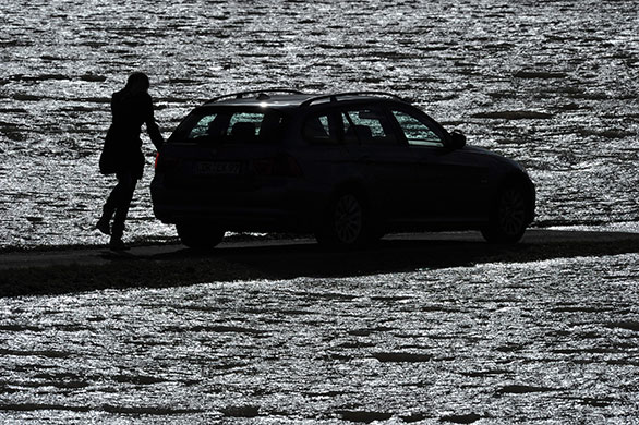 Storm damage in Europe: A woman gets into her car at a partly flooded street in Bunsendorf, Germany
