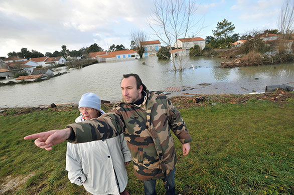 Storm damage in Europe: Two people look at damage caused by heavy floods  in La Faute-sur-Mer