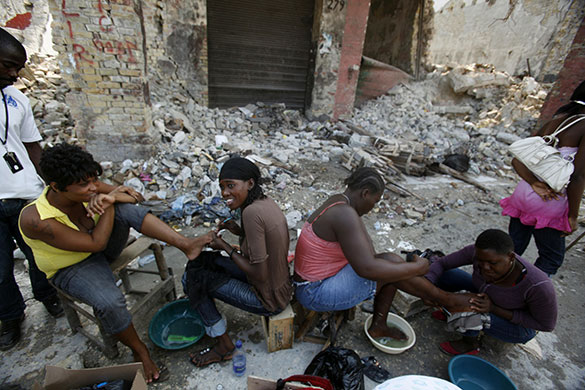 24 hours in pictures: Port-au-Prince, Haiti: Women have their pedicures done amid rubble