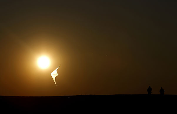 24 hours in pictures: People are silhouetted as they fly a kite during sunset in Berlin