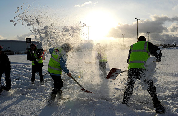 Week in business: Staff clear snow from a car park in Newcastle