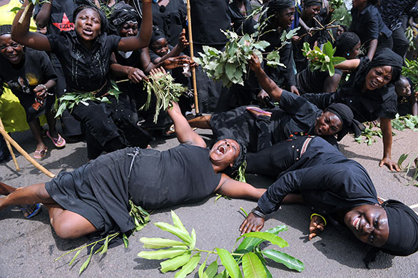 24 hours in pictures: A woman rolls on the road during a womens march, NIgeria