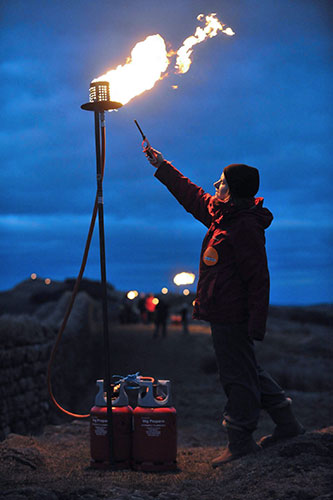 Hadrian's Wall: A volunteer lights her flame as torches are lit