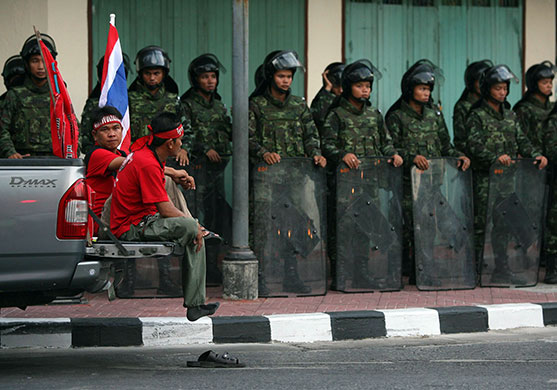 Thailand protests: Supporters of Shinawatra sit in a truck in front of Thai soldiers 