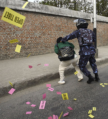 24 hours: Kathmandu, Nepal: A policeman arrests a protester who was dropping leaflets