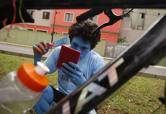 24 hours: Lima, Peru: A cyclist paints himself before attending a protest
