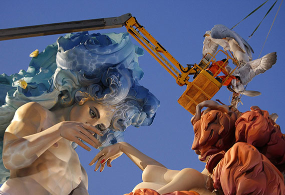 24 hours: Valencia, Spain: Workers attach figurines to a giant sculpture