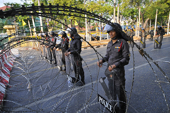 Thailand protests: 15 March: Thai riot police stand behind barbed wire 