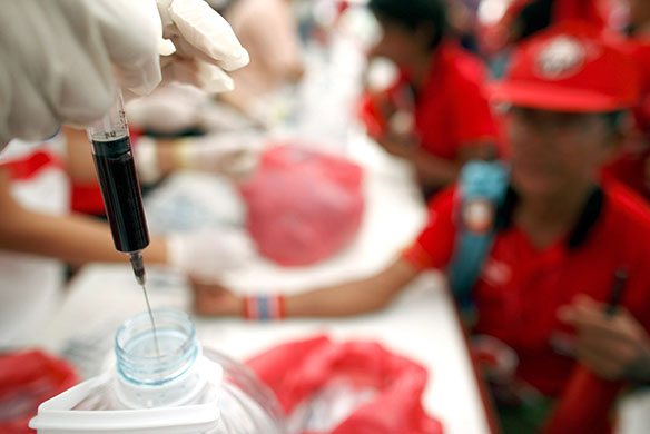 Thailand blood protest: A nurse deposits blood into a bottle