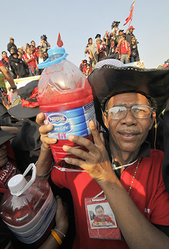 Thailand blood protest: A red-shirted anti-government protester lifts a bottle full of blood