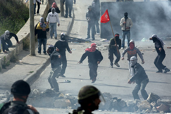 East Jerusalem protests: Palestinian youths throw stones at Israeli soldiers  during clashes