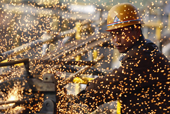 24 hours in pictures: A labourer cuts steel bars at a construction site in Suining