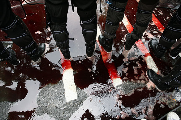 24 hours in pictures: Thai police stand reflected in a pool of blood during red shirt protest