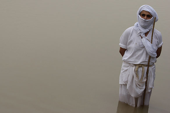 24 hours in pictures: Baghdad, Iraq: A Mandaean stands in the water of the Tigris river