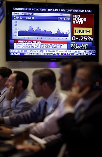 Week in business: A television behind traders on the floor of the New York Stock Exchange
