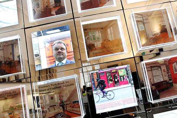 Week in business: A man looks at an estate agent's window display.