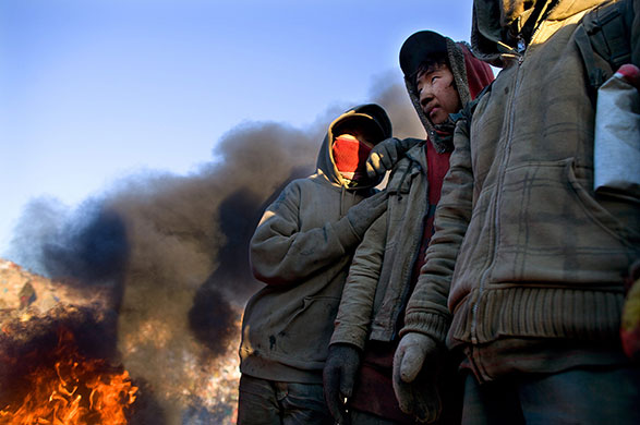 24 hours in pictures: Mongolian boys warm up next to a fire