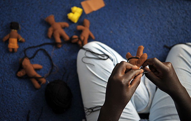 24 hours in pictures: A Kenyan woman creates puppets at one of Nairobi's slums
