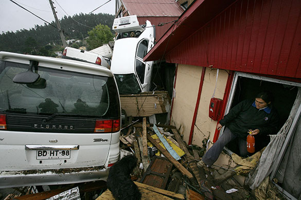 Chile after the quake: A woman rescues belongings from her house in the Chilean city of Dichato