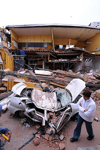 Chile after the quake: A woman walks past a destroyed building  in Concepcion, Chile