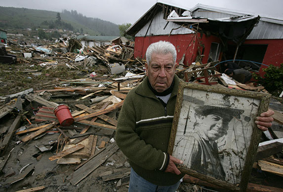 Chile after the quake: Chilean Mario Lantano holds a picture recovered from his house in Dichato