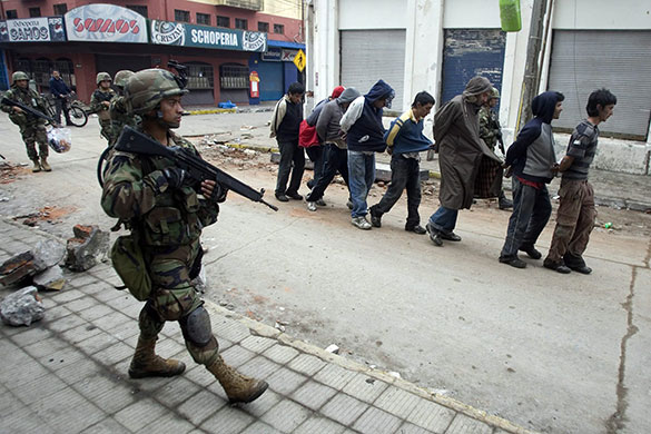 Chile after the quake: Chilean soldiers detain a group of looters in Talcahuano