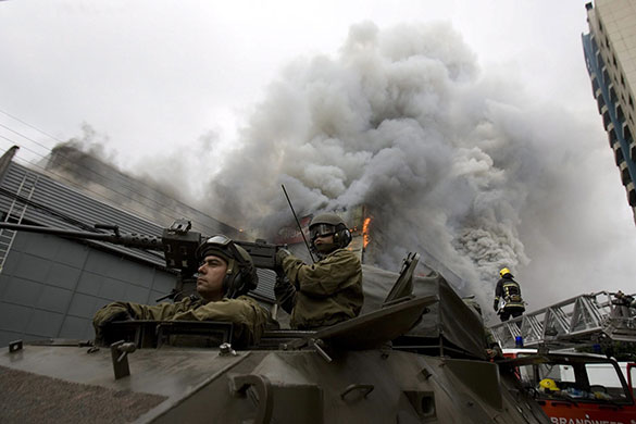 Chile after the quake: Chilean soldiers patrol while a looted store burns in Concepcion